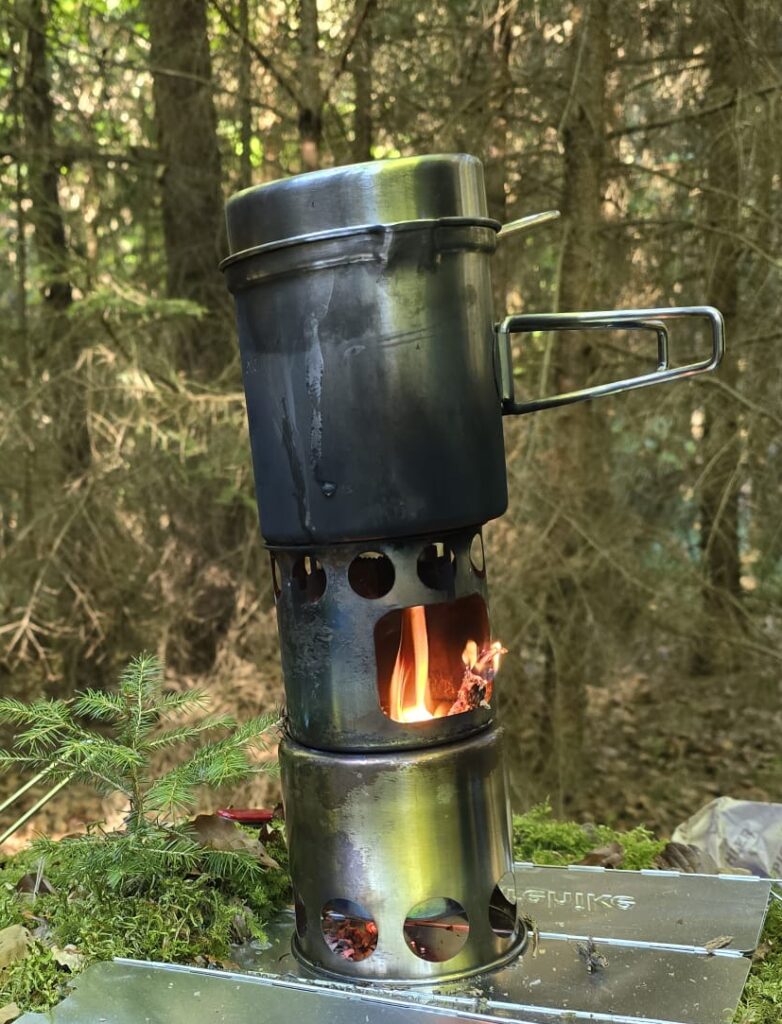 Hobo-Kocher mit Holzfeuer beim Bushcraft im Wald